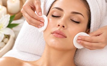 Esthetician cleansing skin with cotton pads